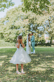 Flower girl covers her eyes while the bride and groom kiss in the background