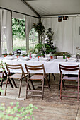 Festlich gedeckte Tische im Gartenpavillon für eine Veranstaltung