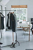 Kleiderstange im minimalistisch gestalteten Arbeitszimmer mit Schreibtisch