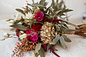 Bridal bouquet with roses and eucalyptus branches on table top