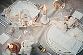 Festlich gedeckter Tisch mit Menükarten, Kerzen und Weingläsern
