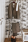 Anzug und Krawatte auf Holzleiter, Schuhe, Vintage-Tapete mit Pferden