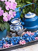 Hydrangea blossoms and tea service on the garden table