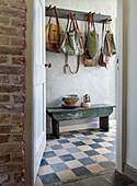 Hallway with chequerboard floor and wooden coat rack