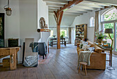 Open-plan living area with wooden ceiling and fireplace, rustic decoration