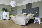 Bedroom with double bed and green accent wall