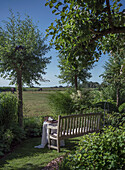 Holzbank im ländlichen Garten mit Aussicht