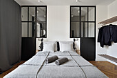 Schlafzimmer mit Doppelbett, Glaspartitur und Garderobe