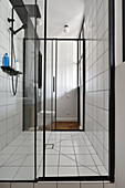 Modern bathroom with glass partition and white tiles