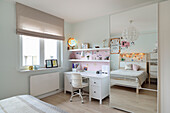 Brightly designed teenager's room with desk, wall shelves, bed and mirror cabinet