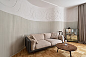 Living room with herringbone parquet flooring and curved relief wall