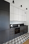 Moderne Küchenzeile in Schwarz-Weiß mit geometrischem Fliesenboden