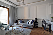 Wohnzimmer mit hellgrauem Sofa und weißer Holzwandverkleidung