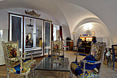 Wohnzimmer mit Bogendecke, barocken Sesseln und Spiegelschrank