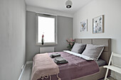 Schlafzimmer mit Doppelbett und grauen Wänden