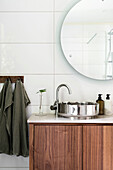 Modern washbasin with round mirror and wooden vanity unit