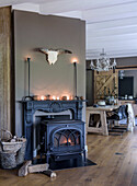 Fireside lounge with wooden floor and rustic dining table in the background