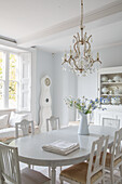 Bright dining room with oval table and chandelier