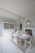 Dining room in shabby chic style with white dining table and crystal chandelier