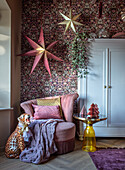 Patterned wallpaper in living room with pink velvet armchair and yellow side table