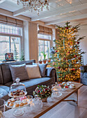 Living room with illuminated Christmas tree and festive coffee table