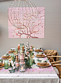 Table set with eucalyptus branches and candles under a large mural