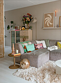 Cosy living room with corner sofa, colourful cushions and disco ball on a fluffy carpet