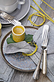 Set table with rustic plates and silver cutlery, napkin ring made of branches with ivy berries