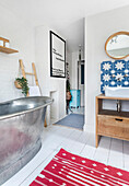 Bathroom with freestanding metal bathtub, blue and white star tiles and red carpet with white pattern