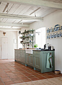 Country-style kitchen with green cupboards and open shelves