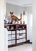 Shelf with stacked magazines and stuffed fox in the entrance area