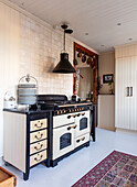 Country-style kitchen with antique stove and black extractor hood