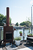 Terrace with river view and outdoor oven surrounded by plants