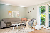 Living room with grey corner sofa and garden access through balcony door