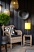 Rustic patio area with rattan armchair and floor lamp