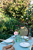 Laid garden table with summer flowers and bread