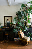 Antique armchair, monstera and painting on the wall