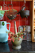 Mortar with dried chilli peppers on kitchen worktop in front of red tiles