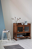 Wooden display cabinet with dried flowers and decoration under sloping roof, white-blue colour scheme