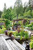 Garden with pond, wooden pergola and lush planting