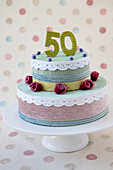 Two-tier DIY cake made of different fabrics with 50 and rose decoration