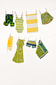 Crafted miniature swimwear in shades of green and yellow on a washing line