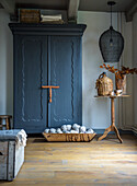 Vintage wardrobe in a rustic living room with wooden decor and wicker furniture