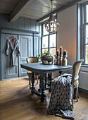 Dining area with dark wooden table, grey wooden panels and candles