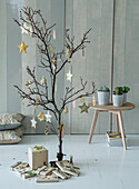 Minimalist, decorative tree with star pendants and succulents on a wooden table