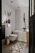 Modern bathroom with white metro tiles and black shower fitting