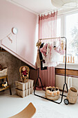 Pastel-colored children's room with clothes rack and storage boxes