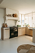 Modern kitchen with wooden furniture, gas hob and hanging lamps