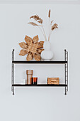 Black wall shelf with minimalist-style decorative elements