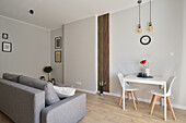 Living room and dining area with grey sofa and white dining table